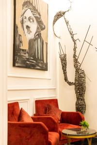 a living room with orange chairs and a painting at Hotel Majestic in Casablanca
