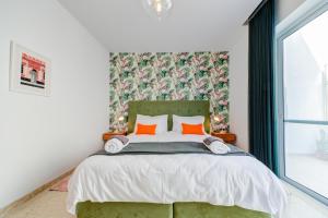 - une chambre avec un grand lit et des oreillers orange dans l'établissement Colorful & Spacious Home with Yard - Close to Xemxija Bay, à San Pawl il-Baħar