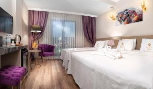 THE NOVA HOTEL في يالوفا: غرفة فندقية بسريرين وكراسي ارجوانية