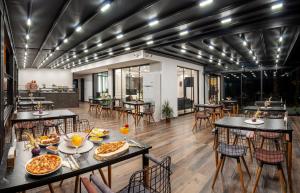 THE NOVA HOTEL في يالوفا: مطعم عليه طاولات وكراسي عليها طعام