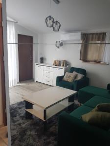 a living room with a couch and a coffee table at Domki nad Nieliszem - dom brzozowy in Nielisz