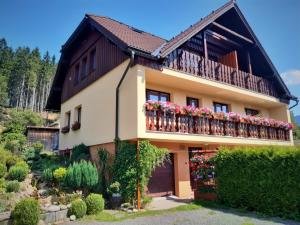 dom z balkonem z kwiatami w obiekcie Apartmány u Jiroušů w Rokitnicach nad Izerą