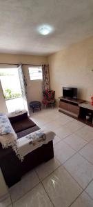 ein Wohnzimmer mit Sofa und Fernseher in der Unterkunft Ap 02-A 50 Metros da Praia Flats Mobiliados para 4 Pessoas in Paulista