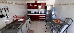 una pequeña cocina con fregadero y armarios rojos en Ap 02-A 50 Metros da Praia Flats Mobiliados para 4 Pessoas, en Paulista