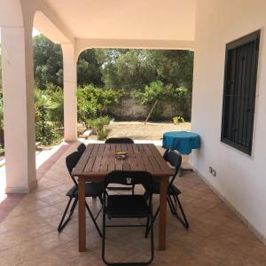 Une table et des chaises en bois sont disponibles sur la terrasse. dans l'établissement Villa Piano Piano, à Carovigno