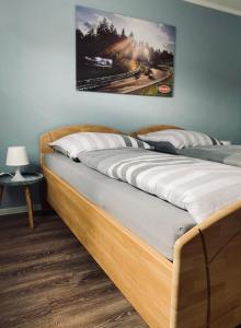 a bed in a room with a picture on the wall at [E]ifeel like Home in Hauroth
