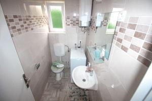 a small bathroom with a sink and a toilet at Apartman Mirno More in Selce +46 photos
