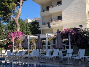 a patio with chairs and umbrellas next to a building at Ascot Hotel Büyükada in Buyukada