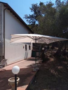 ein weißer Regenschirm vor einem Gebäude in der Unterkunft L'Antica Quercia B&B in CastellʼUmberto