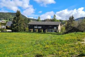 une maison dans un champ avec un champ herbeux dans l'établissement Le Méaudret, à Autrans