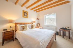 a bedroom with a large white bed and a window at Ardeonaig Hotel & Restaurant in Ardeonaig