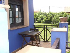 una mesa y sillas en un porche con ventana en Apartamentos y Habitaciones Casa Bego, en Valdredo