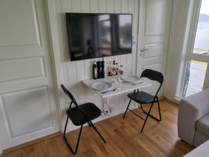 een kleine tafel met twee stoelen en een wastafel in een kamer bij feriehus ved sjøen in Tomrefjord