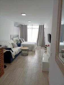 a living room with a bed and a couch at Estudio en la Urbanización de Roquetas de Mar in Roquetas de Mar
