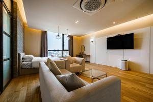 uma sala de estar com um sofá e uma televisão em Brown Dot Hotel Ulsan Jangsaengpo em Ulsan
