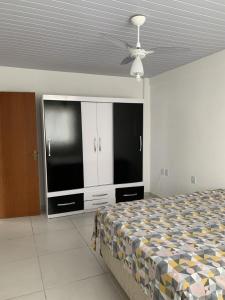 um quarto com uma cama, uma televisão e um tecto em Casa temporada em Florianópolis