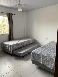 1 dormitorio con 2 camas y ventana en Casa temporada en Florianópolis
