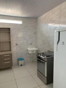 uma cozinha com um fogão e um lavatório em Casa temporada em Florianópolis