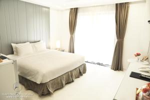 ein Schlafzimmer mit einem Bett und einem großen Fenster in der Unterkunft Fide Hotel in Ho-Chi-Minh-Stadt