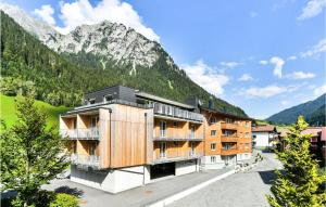 un edificio con una montagna sullo sfondo di Beautiful Apartment In Klsterle With Kitchenette a Klösterle am Arlberg