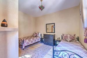 a bedroom with a bed and a mirror at Riad Janoub in Tiznit