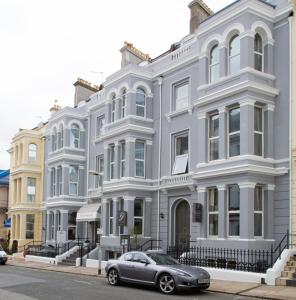 uma casa cinzenta com um carro estacionado em frente em The Grosvenor Plymouth em Plymouth
