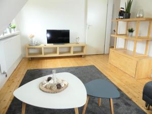 ein Wohnzimmer mit einem weißen Tisch und einem TV in der Unterkunft Ferienhaus Beerennest in Butjadingen