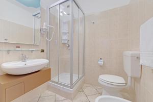 een badkamer met een douche, een toilet en een wastafel bij Hotel Grotto Bagat in Lavena Ponte Tresa
