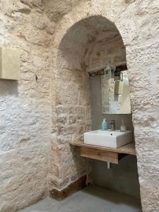a bathroom with a sink in a stone wall at Masseria Croce Piccola - Wineyard in Martina Franca