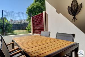 a wooden table and chairs on a balcony at T1 - Rive Gauche 2 étoiles - proche centre Saint-Denis in Saint-Denis