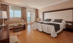 Habitación de hotel con cama grande y sofá en Hipotels Eurotel Punta Rotja Spa-Golf, en Costa des Pins