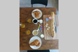 - une table avec deux assiettes de nourriture et de pain dans l'établissement Un petit coin de Bali avec SPA et piscine privés, à Carpentras
