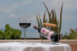 a bottle of wine sitting on a table next to a glass at Hotel Rosina in Makarska