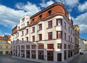 a large white building with a red roof at Buddha-Bar Hotel Prague in Prague