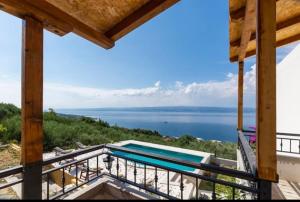 een balkon met een zwembad en uitzicht op het water bij Kuca za odmor Veronika in Jesenice