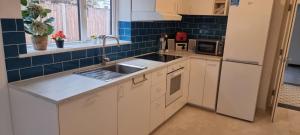 a kitchen with white cabinets and a sink at The Bungalow in Chesterton