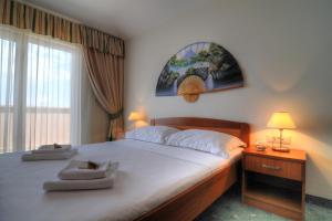 a bedroom with a large bed and a window at Hotel Rosina in Makarska