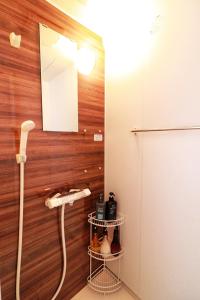 Kaigandōri的住宿－ゲストハウス WAKURIAN-Iwatacho，浴室设有木墙电话