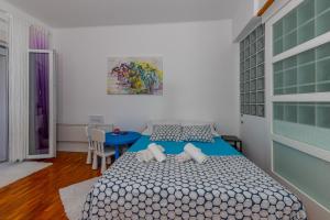 una camera con letto e tavolo blu di Crikvenica Right On The Beach a Crikvenica