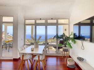 a dining room with a table and chairs and the ocean at Viela Vie by LovelyStay in Caniço