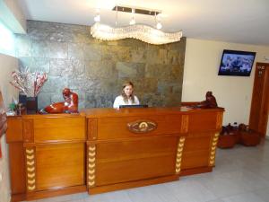 a woman sitting at a desk in a room at Hotel Flamingo in Puerto Ayora