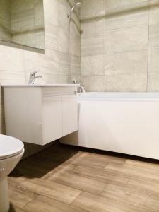 a bathroom with a sink and a tub and a toilet at Yin Shan Hotel in Zhongzheng