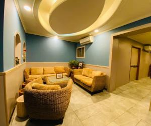 a living room with wicker furniture and a circular ceiling at Yin Shan Hotel in Zhongzheng