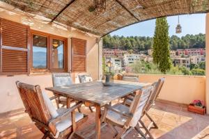 Une table et des chaises en bois sont disponibles sur la terrasse. dans l'établissement Villa Carla, à Port de Sóller