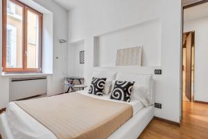 a white bedroom with a bed and a window at Easylife - Wonderful & Stylish house in the center in Milan