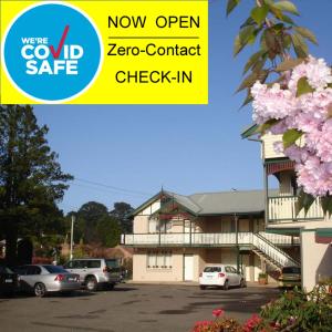 a building with cars parked in a parking lot at Three Explorers Motel in Katoomba