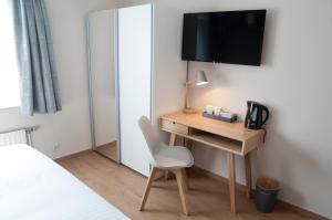 een kamer met een bureau met een stoel en een televisie bij Wellintown Guest House in Waterloo