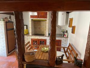 a kitchen with a wooden table and a fireplace at Quinta Vale do Cabo in Riba Douro