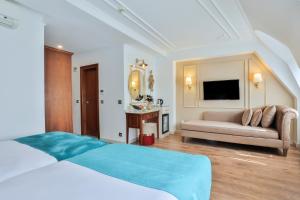 a hotel room with a bed, couch and a television at Orient Express & Spa by Orka Hotels in Istanbul