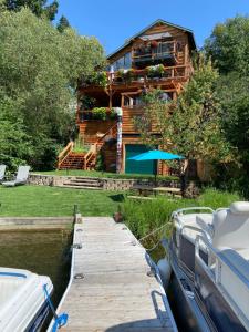 a house on the water with a dock and a boat at THE INN Bigfork Bay in Bigfork